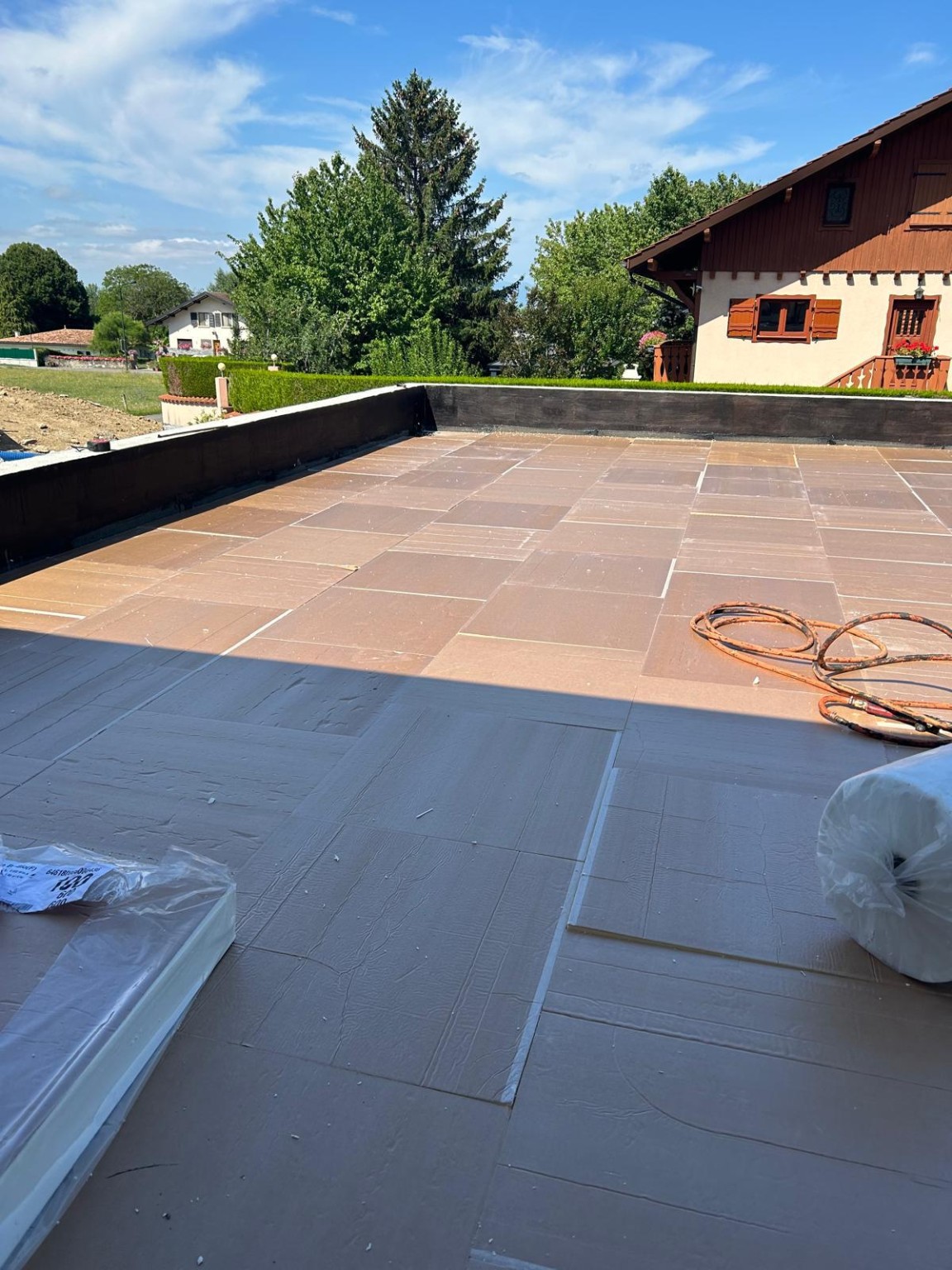 Panneaux isolants posés sur une toiture-terrasse, avec les relevés périphériques visibles