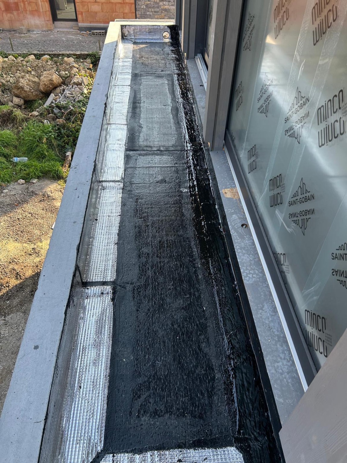 Membrane d’étanchéité et relevés au pied d’une baie vitrée, pendant les travaux